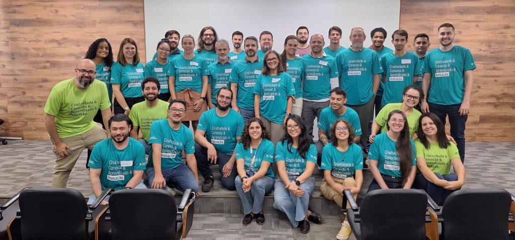 Participantes do evento de reinauguração do prédio da Incamp vestidos com camisas na cor verde Fim da descrição.