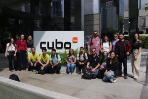 Equipe que visitou os dois hubs reunida em área externa do prédio, em frente ao logo do Cubo Itaú. Fim da descrição.