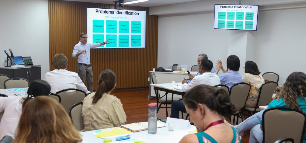 Em primeiro plano, participantes do workshop. Em segundo plano, Matheus Provinciali ministrando o curso.