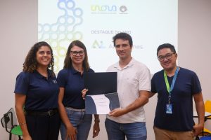 Luciana Silva, Mariana Zanatta Inglez, Lucas Fonseca e Vital Yasumaru posam para foto durante premiação. Fim da descrição.